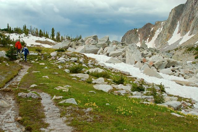 two people hiking on a mountain trail