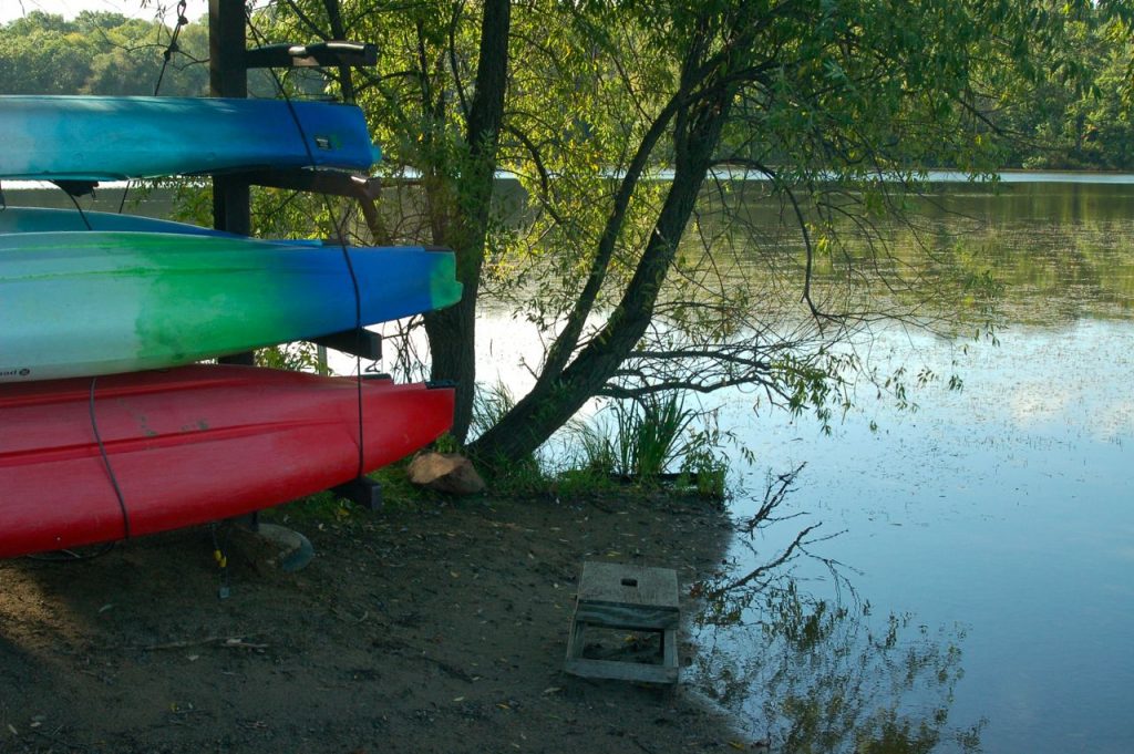 kayaks on a rack next to a lake