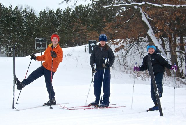 three kids cross country skiing