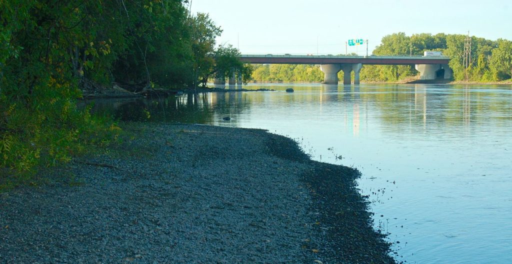 gravel beach along the Mississippi River with Hwy 694 bridge over the river