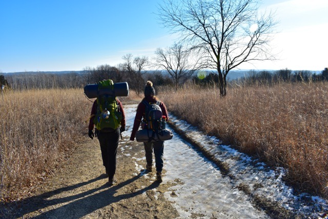 two women backpacking out of the campground area at afton state park
