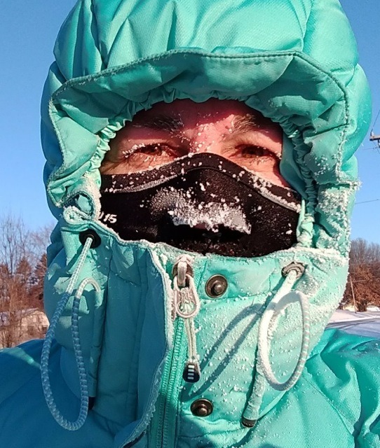 woman's headshot with hood on, face mask on and very frosty