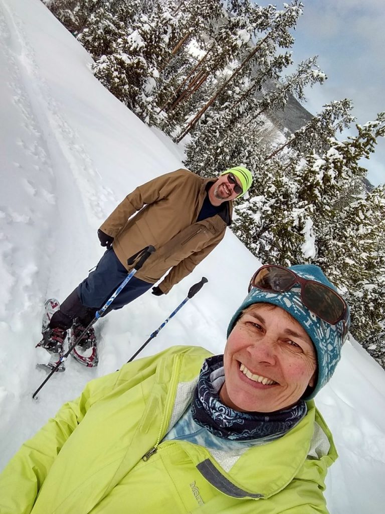 two people snowshoeing, one wearing a marmot precip jacket