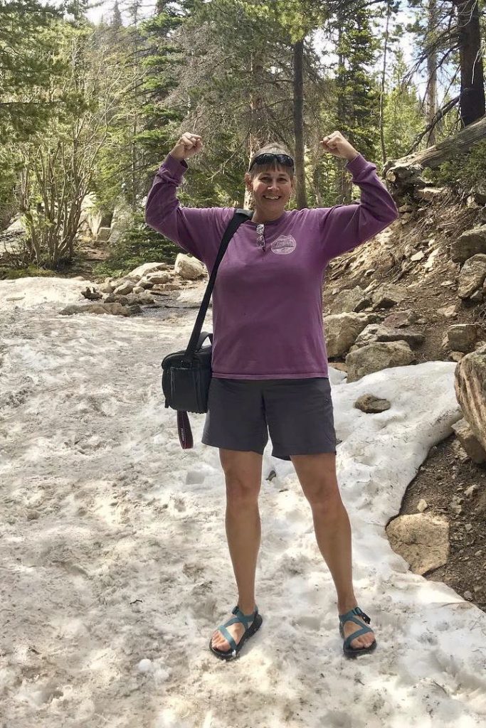 woman wearing chacos and shorts on a snowy hiking trail