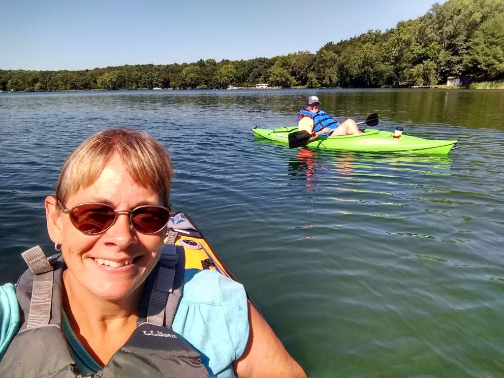 two women kayaking on square lake, including the author
