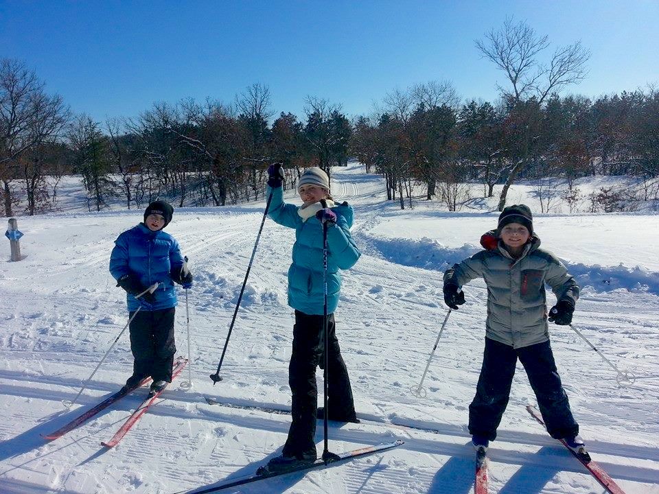 three kids cross country skiing