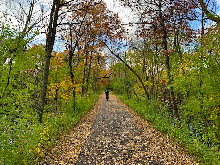 biker on a paved trail in the fall