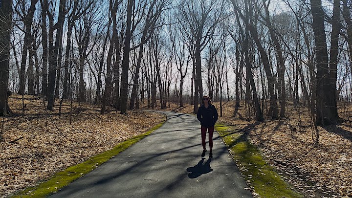 woman hiking on a paved trail in lake rebecca park reserve in early spring