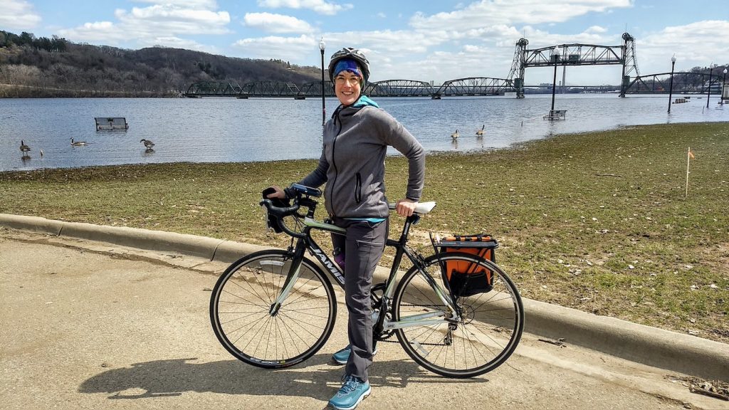 katy with her bike in stillwater at the st croix river, spring flood season