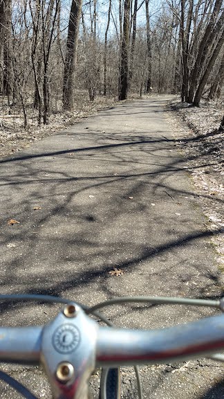 overlooking the bike handlebars to the paved bike trail, early spring
