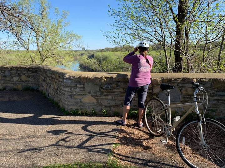 biker standing at a wall at fort snelling overlooking the river
