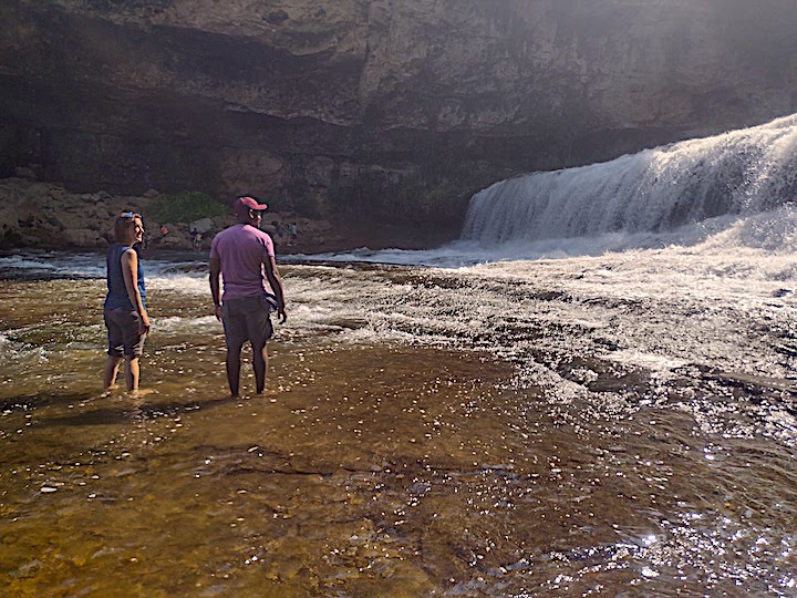 a woman and man standing in the river just below Willow Falls