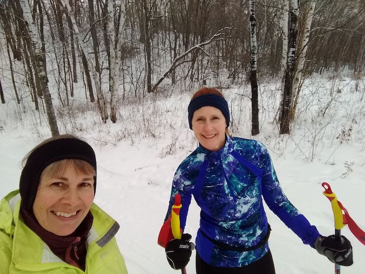 two women cross country skiing together