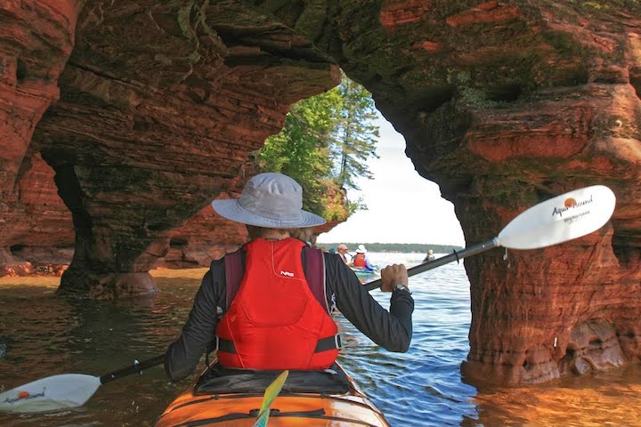woman kayaking in a sea cave with the Aqua Bound Sting Ray Hybrid kayak paddle