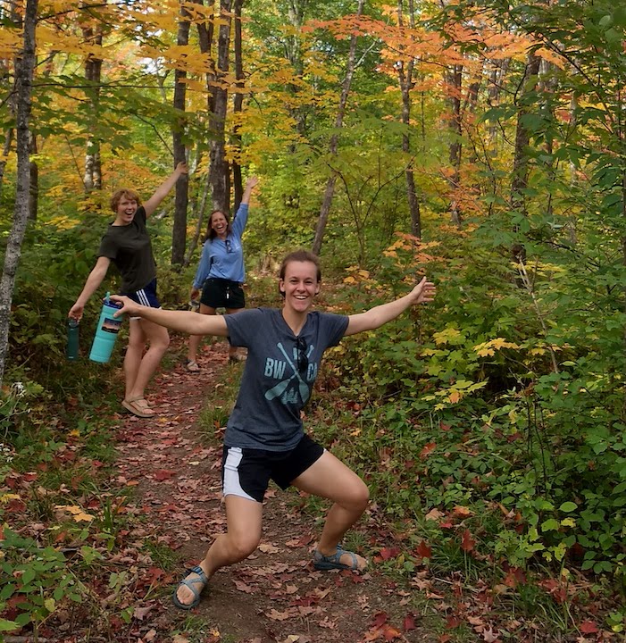 three young women hiking in the woods in the fall - smiling and happy!