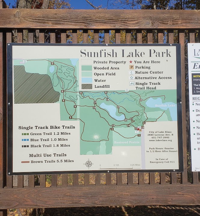 Sunfish Lake Park trail map on a wooden sign