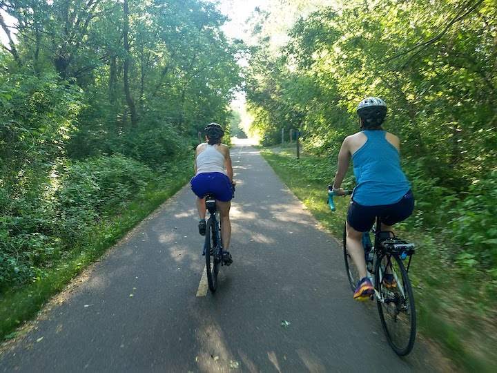 2 women on a bike trail in the woods