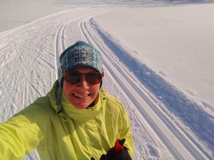 woman with Marmot Precip jacket cross country skiing