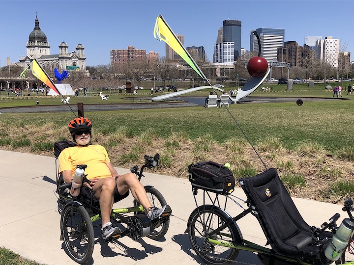 man on a recumbent trike in front of Mpls famous spoon & cherry sculpture