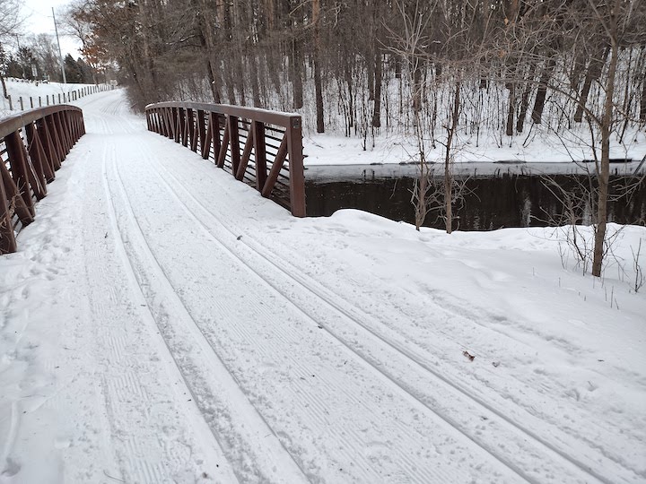 groomed ski trials cross a short bridge