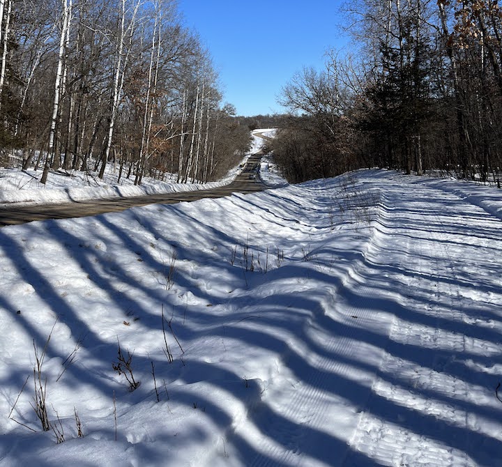 plowed road and packed trail run parallel downhill