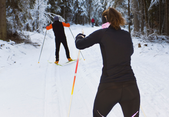two skate skiers on a wooden trail