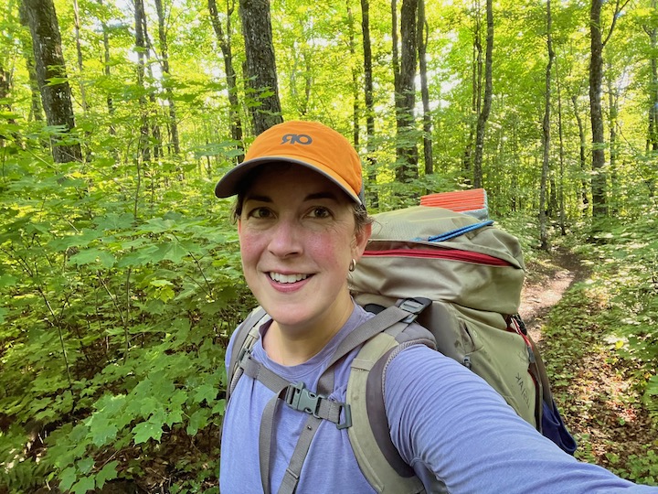 woman with a backpack on a wooded trail