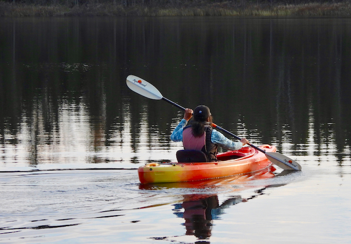 woman kayaking on a calm lake