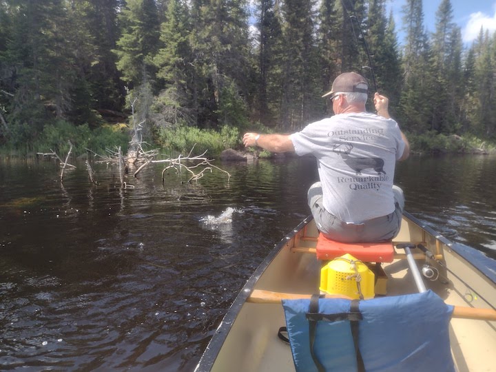 man fishing from a canoe