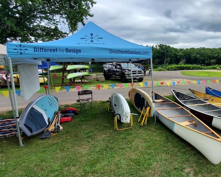 Grey Duck booth with paddle boards and canoes ready for a demo day