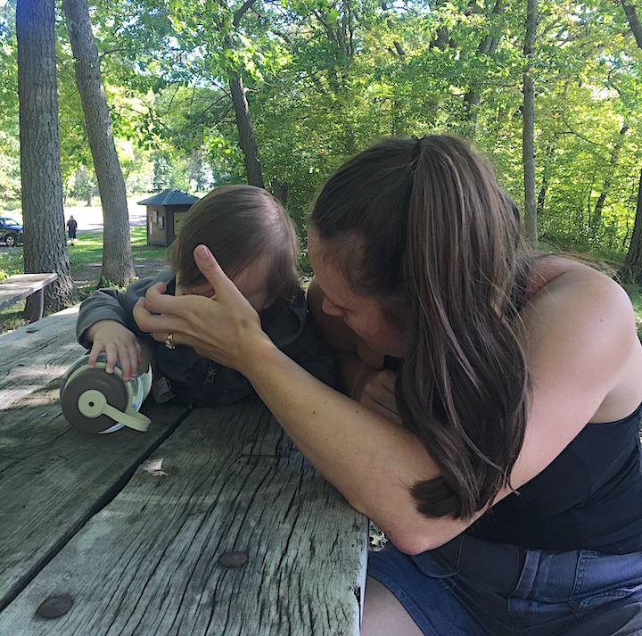 young mom with her baby at a campsite picnic table